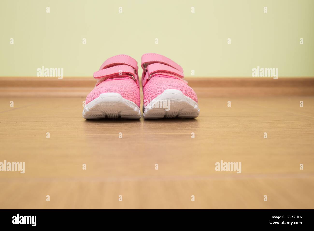 Kinder rosa Sommer Turnschuhe sind gegen eine grüne Wand die Schuhe sind aus nächster Nähe. Stockfoto