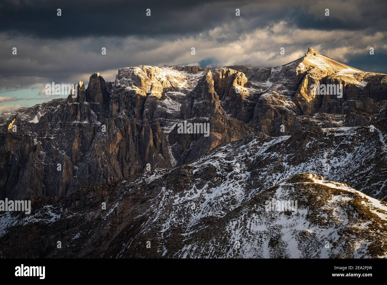 Wolken, die Gipfel der Puez Gipfel der Puez-Geisler Berge der Dolomiten leuchten dramatisch in der goldenen Abendsonne, Südtirol, Italien Stockfoto