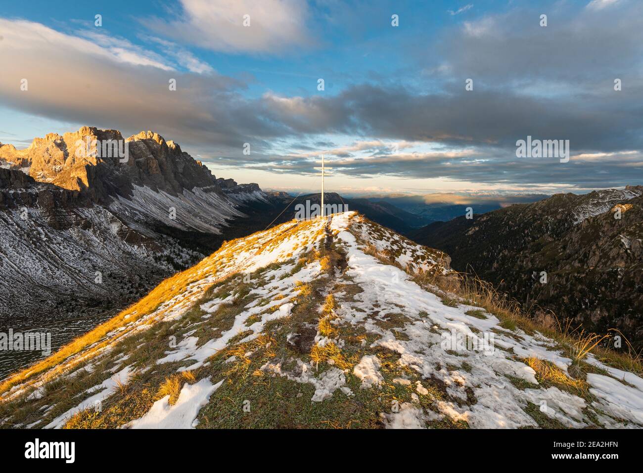 Gipfelkreuz des Zendleser Kofel und Blick auf die Puez-Geisler Berge in den Dolomiten im Herbst in der Morgensonne, Südtirol, Italien Stockfoto