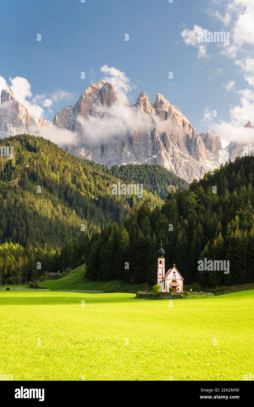 Herbstlandschaft der Dolomiten mit der Ranui Kapelle in Villnöss vor Wäldern und Felsen der Puez-Geisler Gipfel in Sonnenschein, Südtirol Stockfoto