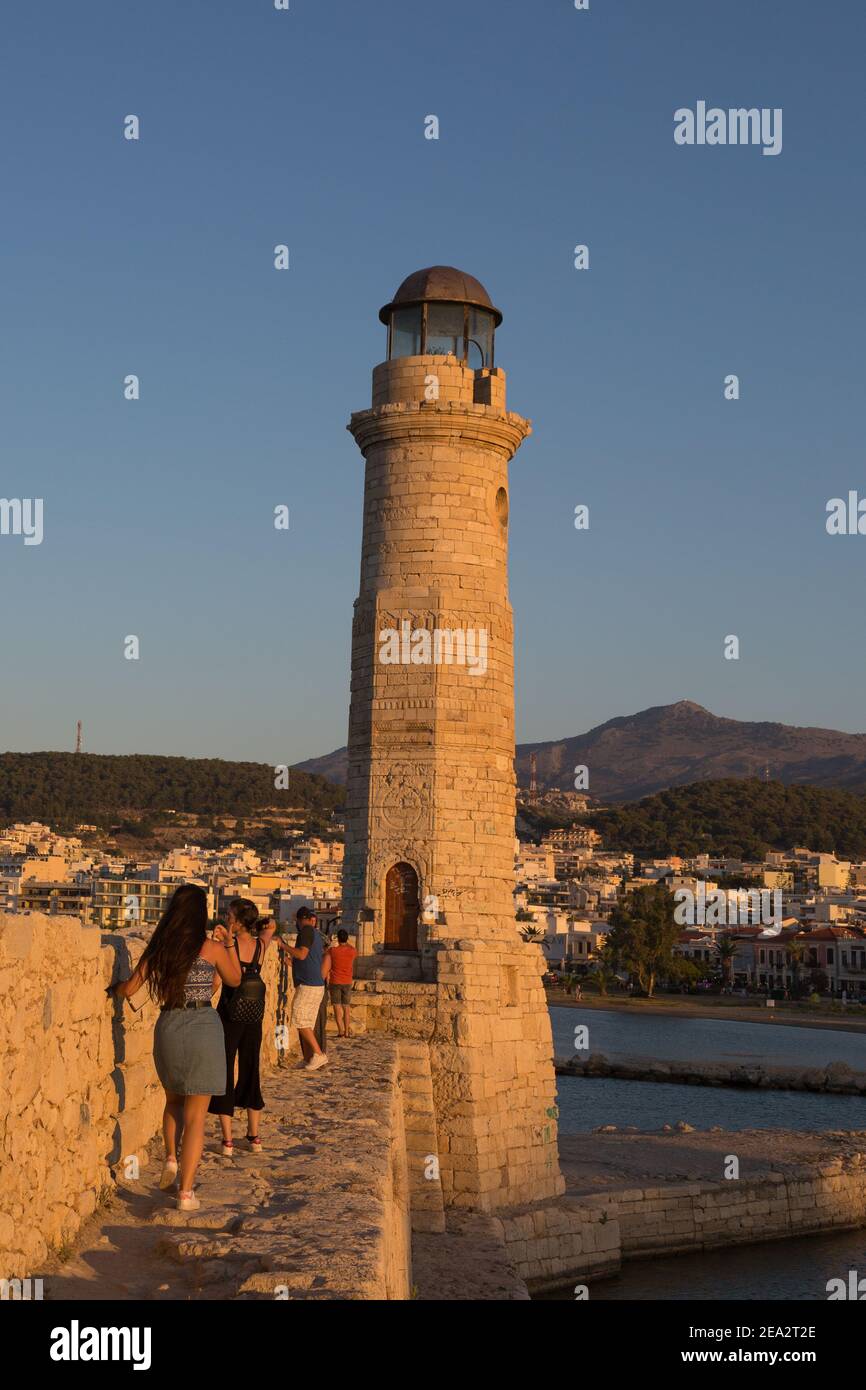 Rethymno, Kreta/Griechenland-07 08 2017: Der Leuchtturm ist bei Sonnenuntergang in der Altstadt von Rethymno. Menschen, die das Wahrzeichen besuchen und an der Mauer entlang gehen Stockfoto