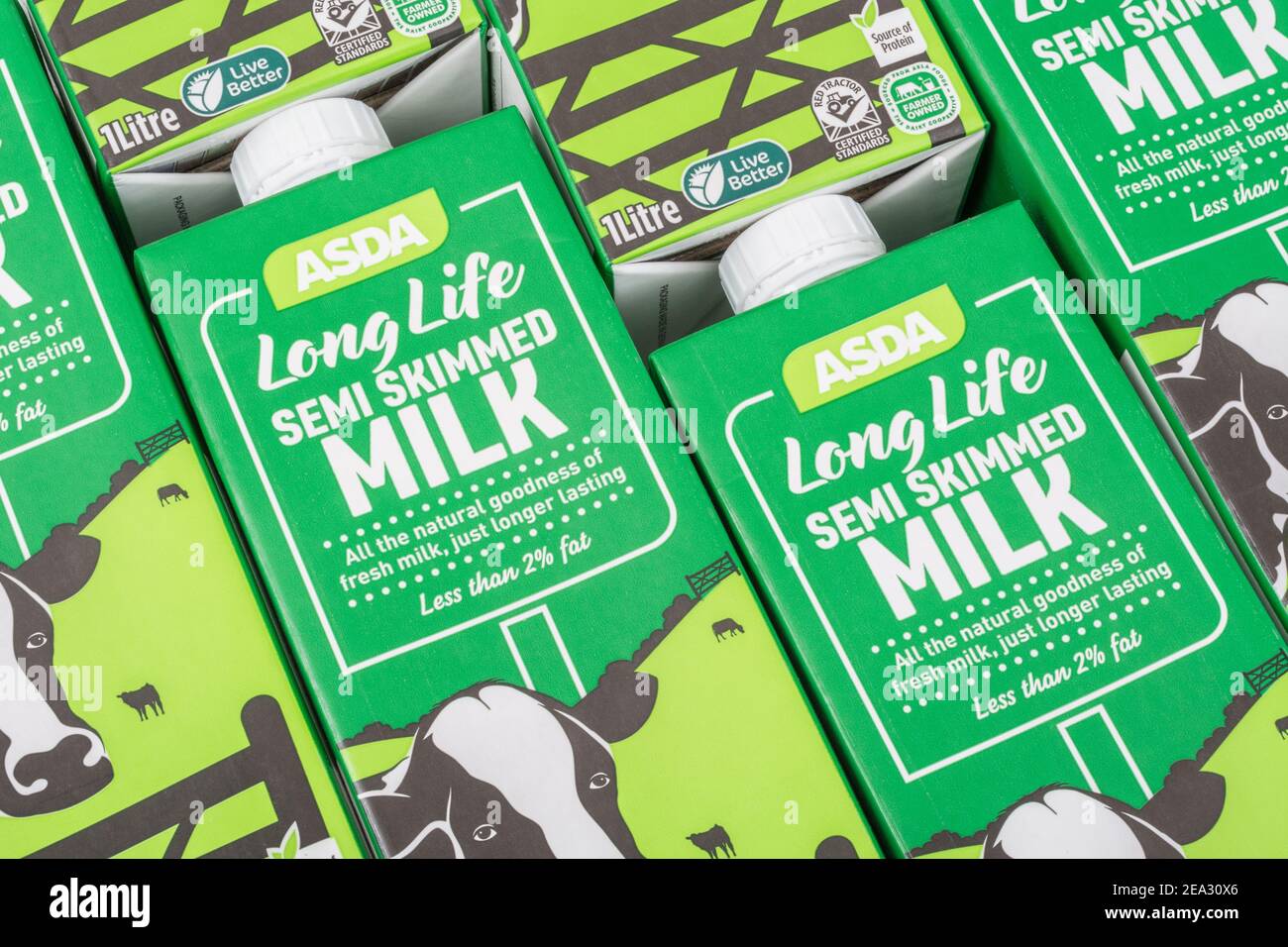 Nahaufnahme von Papierkartons mit ASDA-Eigenmarke langlebiger UHT-Halbmagermilch. Für britische Lebensmittel, britische Milchindustrie, Milchproduktion Großbritannien. Stockfoto
