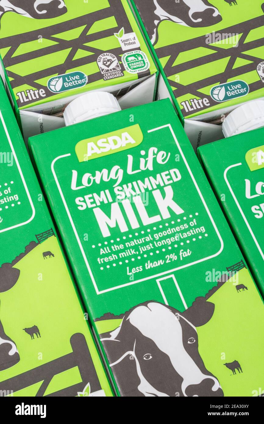 Nahaufnahme von Papierkartons mit ASDA-Eigenmarke langlebiger UHT-Halbmagermilch. Für britische Lebensmittel, britische Milchindustrie, Milchproduktion Großbritannien. Stockfoto