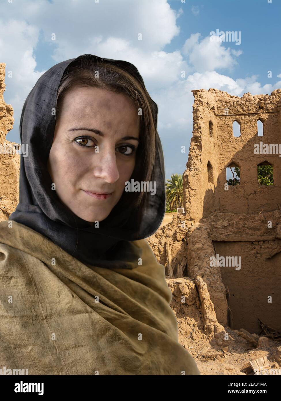 Portrait der Frau mit Hijab und Dorfruinen in der Hintergrund Stockfoto