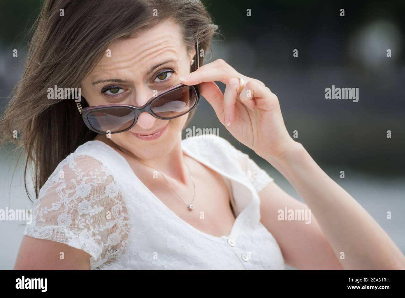 Porträt einer jungen kaukasischen Frau, die über eine große Sonnenbrille schaut Stockfoto