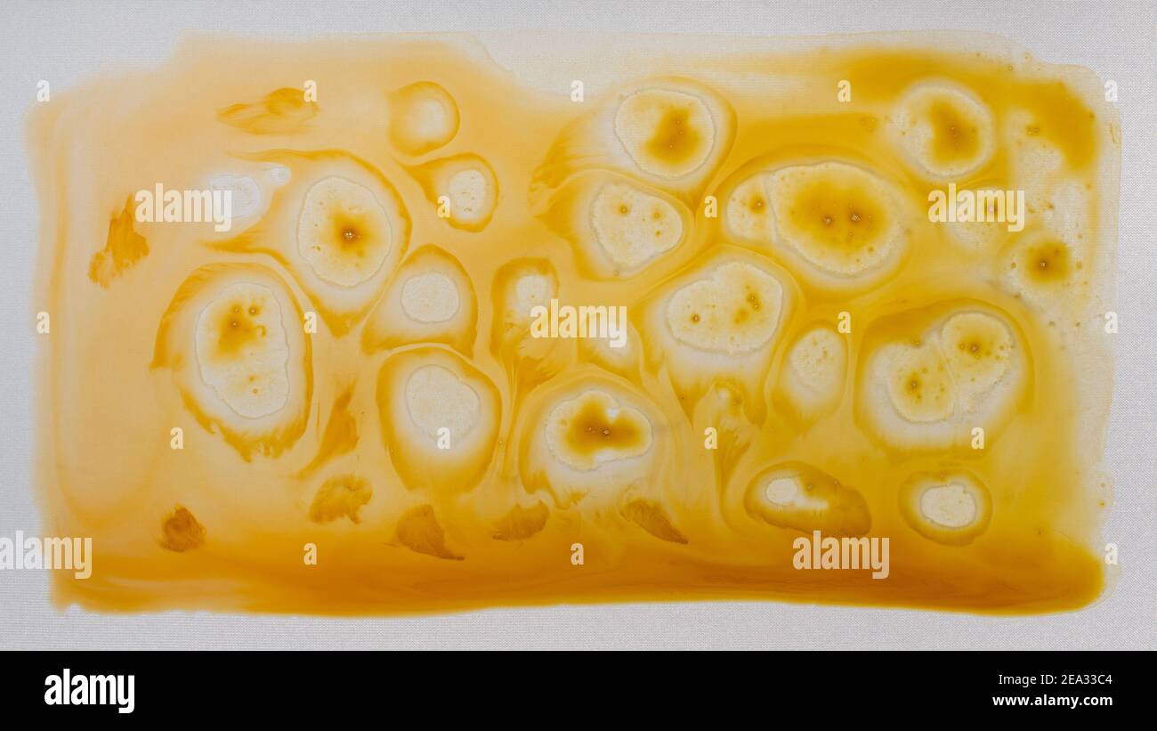 Abstrakt gelb malen Hintergrund. Farbflecken und Spritzer. Flüssige Kunst Stockfoto