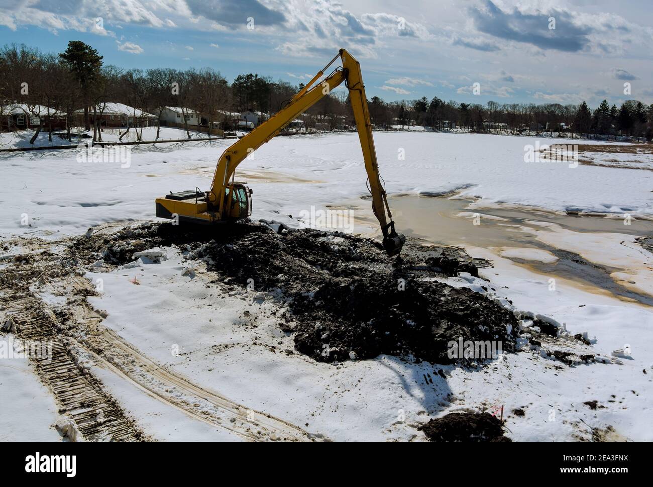 Reinigung der Boden des Sees mit einem Bagger Bagger Bagger Im Winterschnee Stockfoto