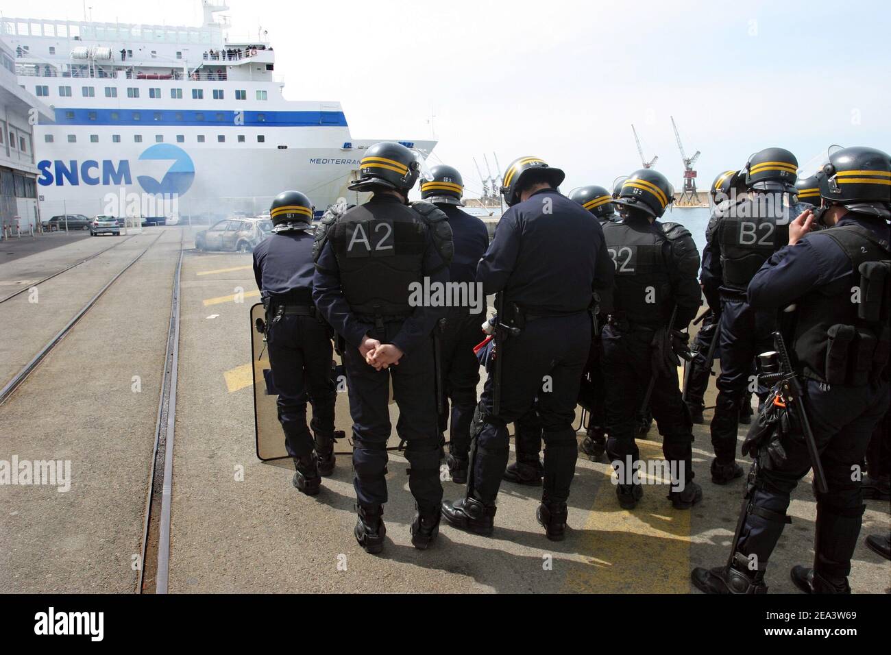 Französische Seeleute der Reederei SNCM (National Maritime-Corsica Mediterranean Company) streiken, besetzen die Fähre "Mediterranee" und verbrennen Autos, während Polizisten am 18. April 2005 im Hafen von Marseille, Südfrankreich, vorbeischauen. Die Demonstranten streikten gegen die Verabschiedung der Gesetzgebung zur Schaffung eines neuen Low-Cost-Registers der Französischen Internationale. Foto von Gerald Holubowicz/ABACA Stockfoto