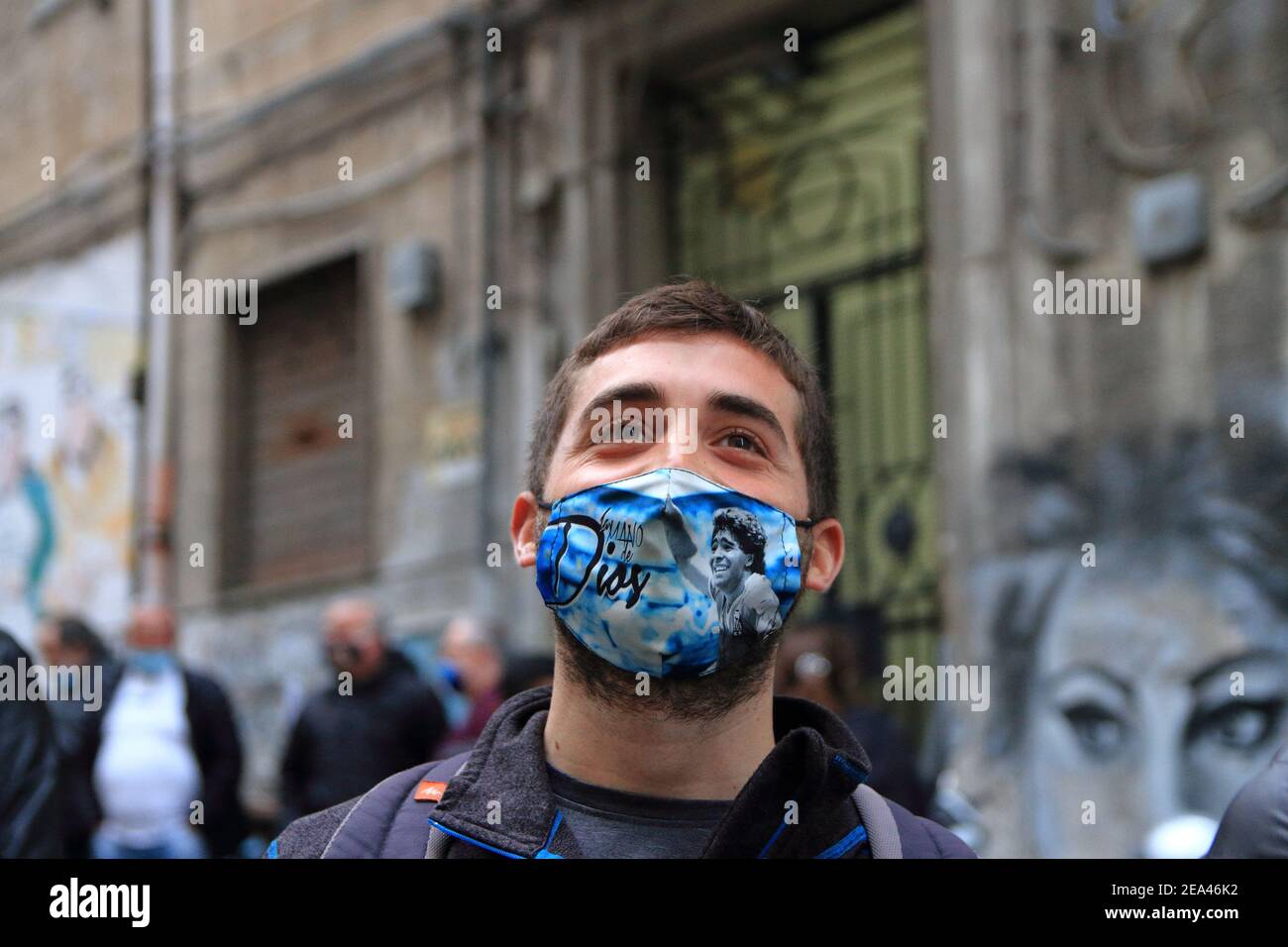 Ein junger Fan von Neapel mit Maske, gemalt mit Bildern von Maradona, schauen Sie sich die Bilder der Pibe de Oro , in den spanischen Viertel. Stockfoto