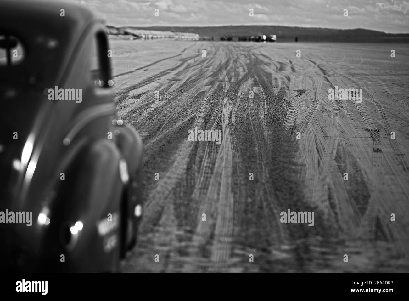 Amerikanischer Oldtimer mit Reifenspuren beeindruckt im Strandsand beim Hot Rod Racing pendine Sands in Wales, Großbritannien.Reifenspuren auf dem Sand während des Rennens. Stockfoto