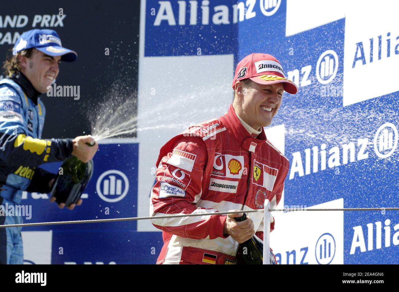 Renault's Fernando Alonso aus Spanien sprüht Champagner auf Ferrari's Michael Schumacher aus Deutschland, nachdem er am 3. Juli 2005 den französischen Grand Prix auf der Magny Cours Rennstrecke in Zentralfrankreich gewonnen hat. Alonso gewann das Rennen vor McLaren's Kimi Räikkönen aus Finnland auf dem zweiten Platz und Ferrari's Michael Schumacher aus Deutschland, der den dritten Platz belegte. Foto von Thierry Gromik/ABACAPRESS.COM Stockfoto