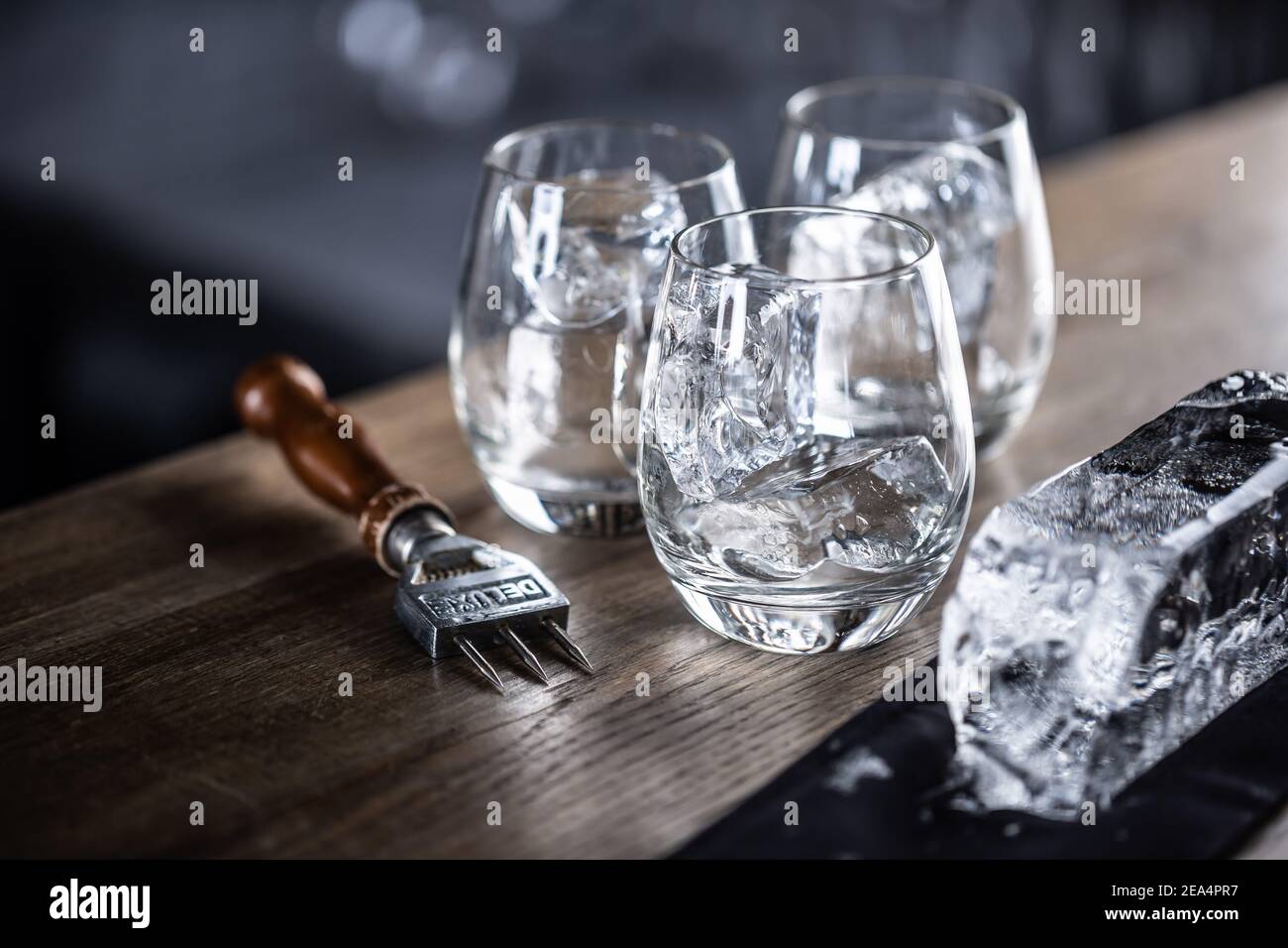 Gläser gekühlt für Cocktails mit Eis mit einem großen Eiswürfel und Eis Chopper beiseite. Stockfoto