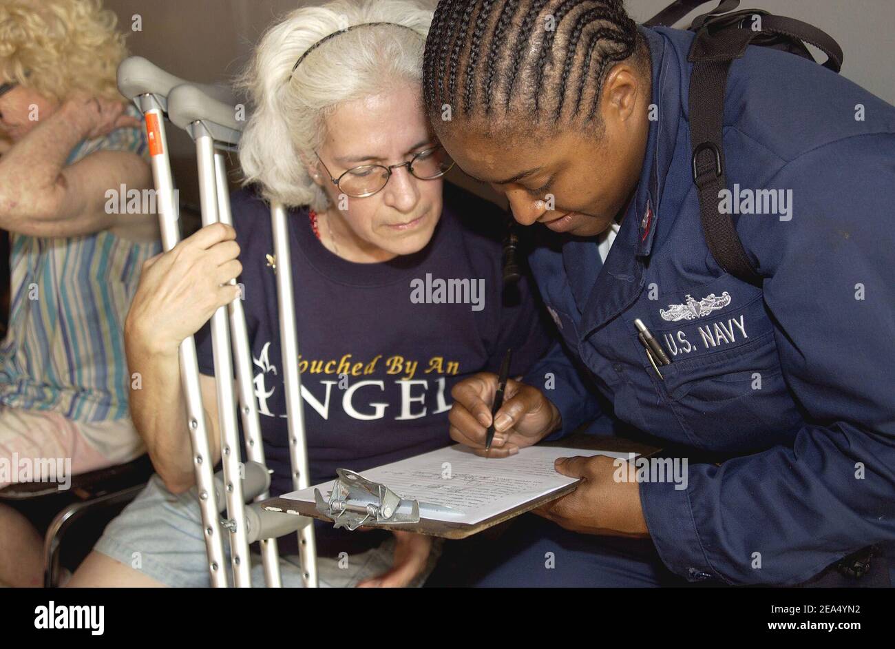 Eine US Navy Sailor hilft einem Hurrikan Katrina Opfer füllen Papierkram, nachdem sie das Dock Landungsschiff USS Tortuga transportiert wurde (LSD 46). Derzeit in New Orleans angedockt, Tortuga bietet warme Mahlzeiten, Duschen und Betten zum Schlafen für die Opfer. Die Beteiligung der Marine an humanitären Hilfsmaßnahmen wird am 5. September 2005 von der Federal Emergency Management Agency (FEMA) gemeinsam mit dem Verteidigungsministerium in New Orleans, LA, geleitet. Foto von Michael B. Watkins/USN via ABACAPRESS.COM Stockfoto