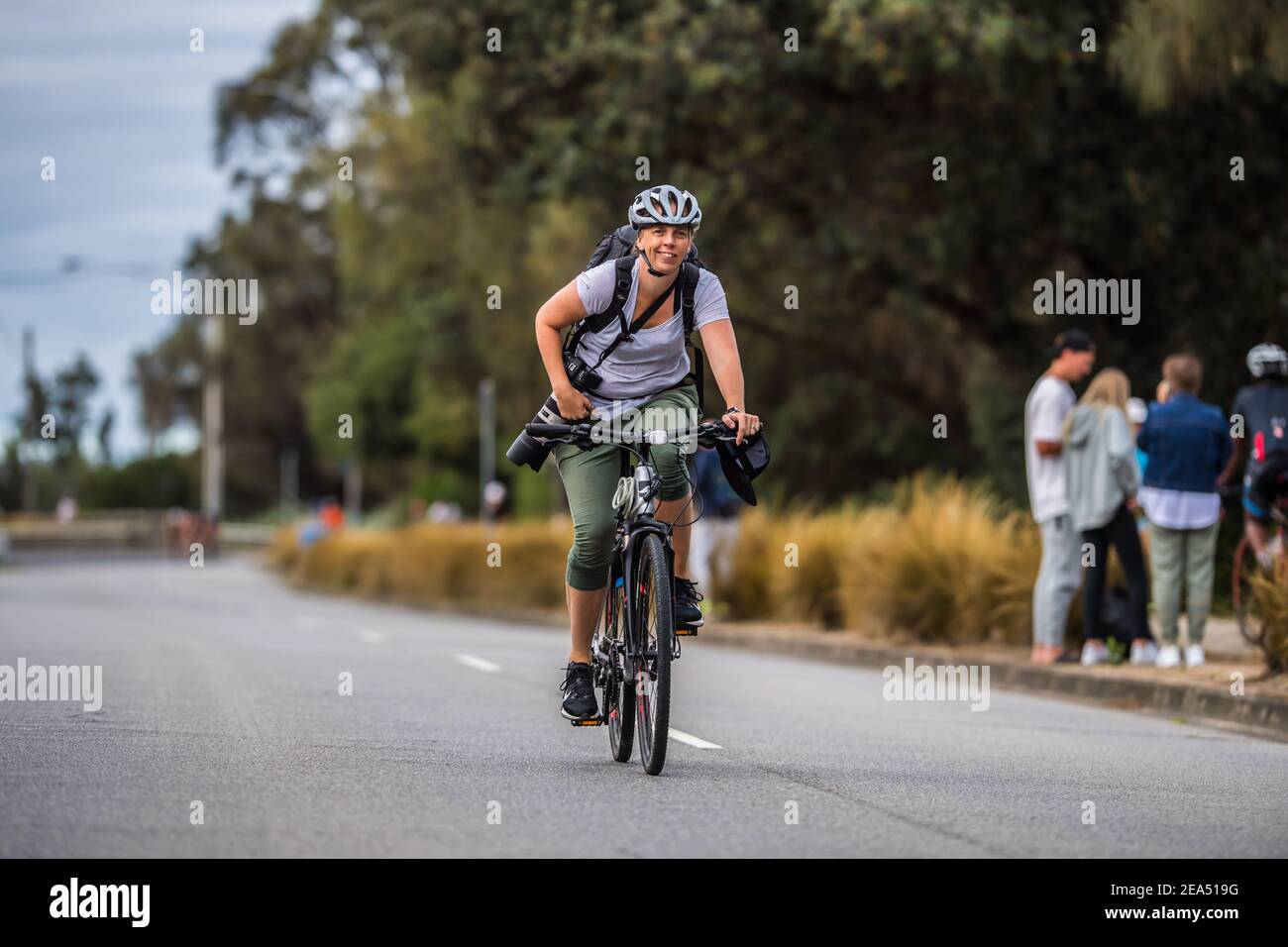 Sportfotograf Stef Hanson fährt ihr Fahrrad mit einer Kamera an der Seite während der Triathlon Series 2021 2XU, Rennen 2 am Sandrigham Beach. Stockfoto