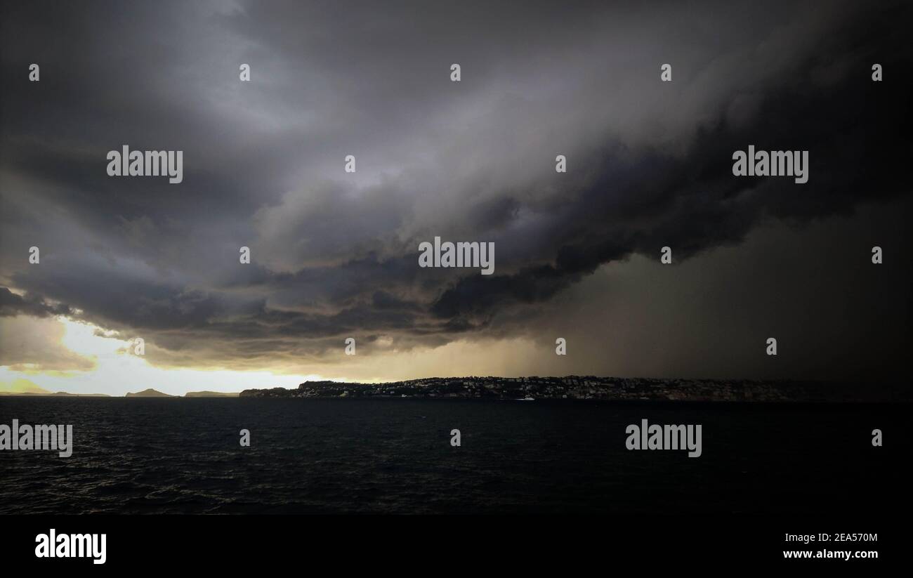 Gewitterwolken über dem Meeresspiegel, unglaubliche Regenwolken, ungewöhnliches Wetter, Klimawandel, düstere Wolken Stockfoto