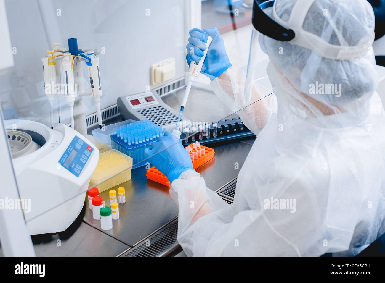 Laborassistent in Schutzanzug und Maske in einem modernen prc-Labor. Stockfoto