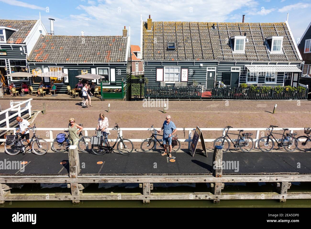 Während der Pandemie warten einige Besucher am Kai des malerischen, typisch holländischen Dorfes und Hafens von Marken, Nordholland, Niederlande Stockfoto