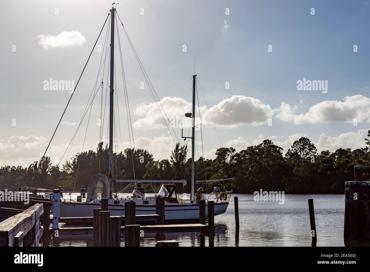 Ein Segelboot legt an einem Pier entlang des St. Lucie River an der St. Lucie Lock and Dam in der Nähe von Stuart, Florida, USA an. Stockfoto