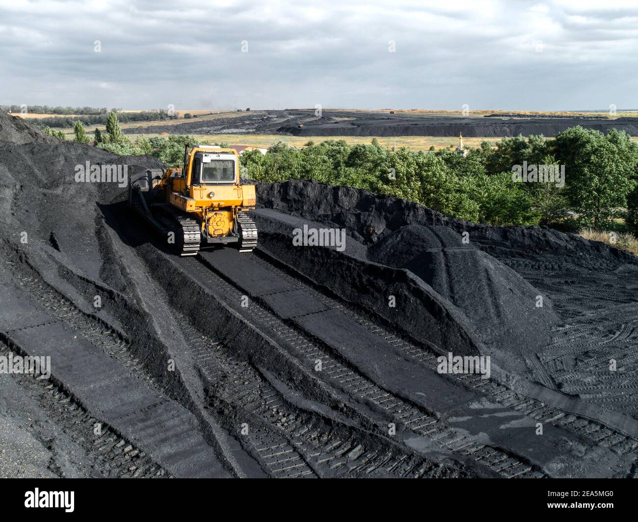 Bulldozer schiebt Steinkohle. Großer Kohlehaufen. Stockfoto