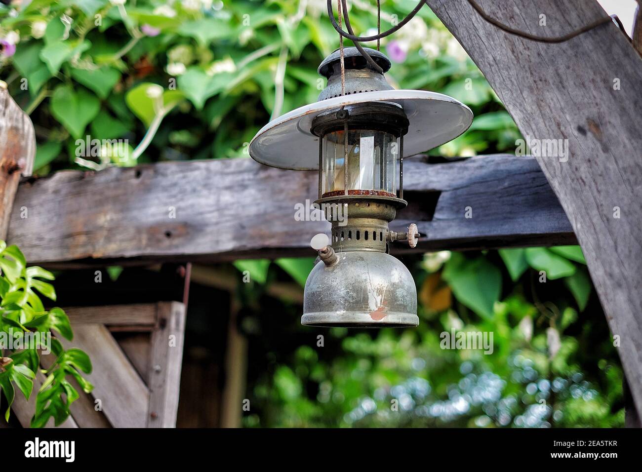 Eine antike Öllampe aus Metall, die als Dekoration in einem Garten verwendet wird. Stockfoto