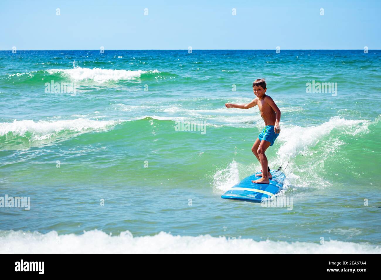 Junge 10 Jahre alt Junge Aktion Foto Fahrt Surfbrett auf Eine Welle im Meer Stockfoto