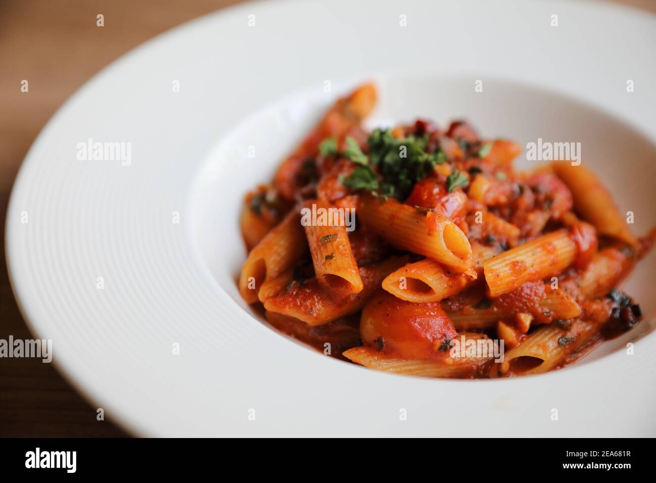 Penne arrabiata Pasta Tomatensauce mit Gewürzen italienische Küche auf Holzhintergrund Stockfoto
