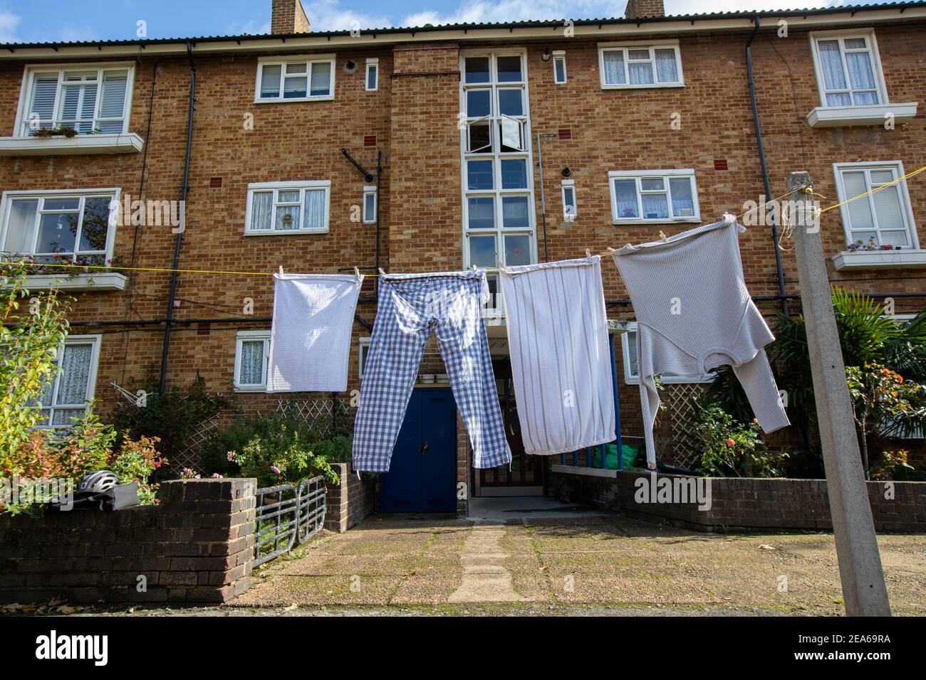 Wäscheständer an einer Wäscheleine im Innenhof eines Wohnblocks in London. Schlafanzughose, Handtuch, Pullover Stockfoto