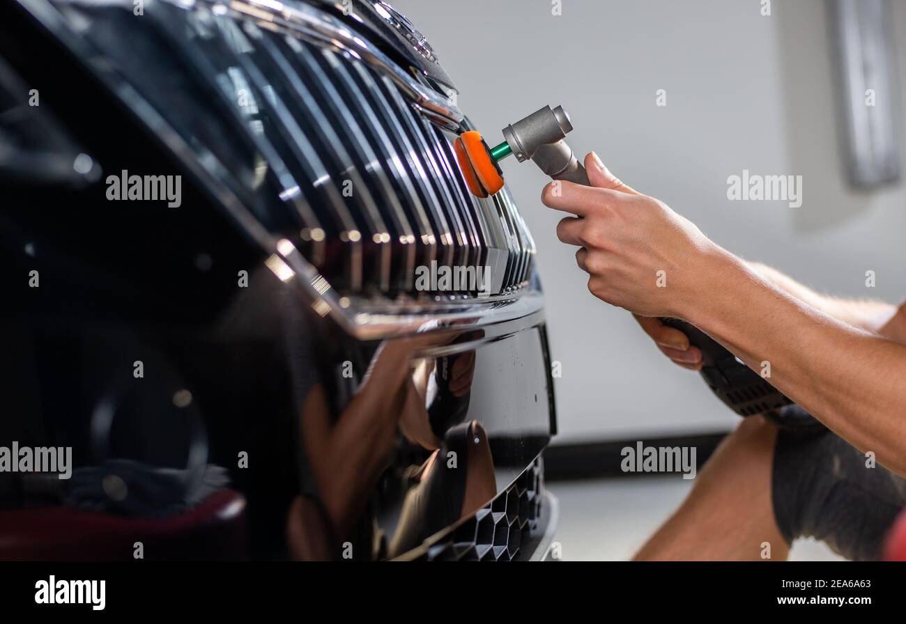 Schwarzes auto Kratzer entfernen. Ein Mann hält ein Auto polieren Werkzeug  in der Garage Stockfotografie - Alamy