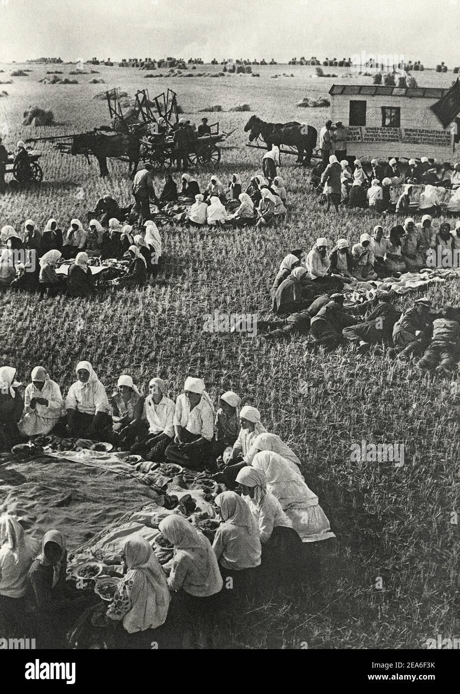 Die Sowjetunion im Jahre 1930s. Das Leben auf einem sowjetischen Kolchos. Bei der Ernte Mittagessen auf dem Feld. Sowjetisches Propagandabuch. UdSSR, 1930s Stockfoto