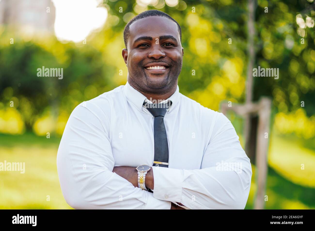 Porträt eines glücklichen afroamerikanischen Geschäftsmannes, der die Kamera anschaut und lächelt. Stockfoto