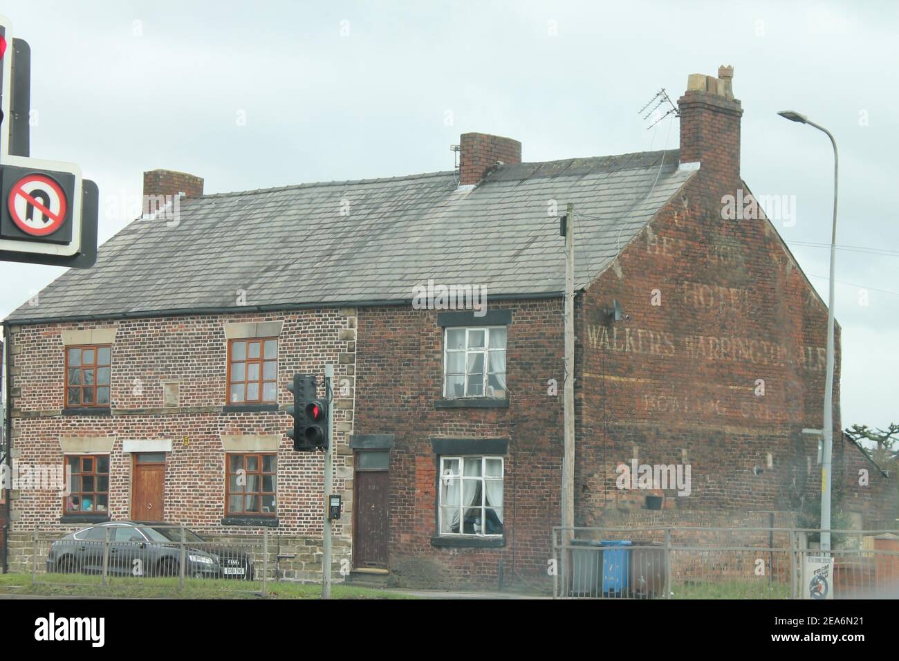 Haus an der Warrington Road, Wigan mit verblassten Farben auf dem Giebel, der für das Ben Johnson Hotel, Walkers Warrington Ales, wirbt Stockfoto