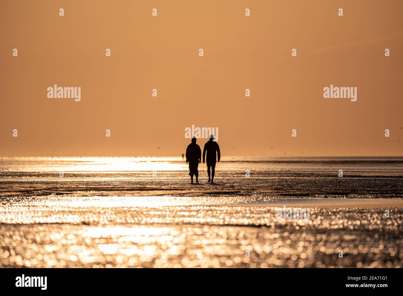 Menschen bei Sonnenuntergang im wattenmeer in Cuxhaven bei Sonnenuntergang - Menschen im Watt von Cuxhaven im Sonnenuntergang Stockfoto