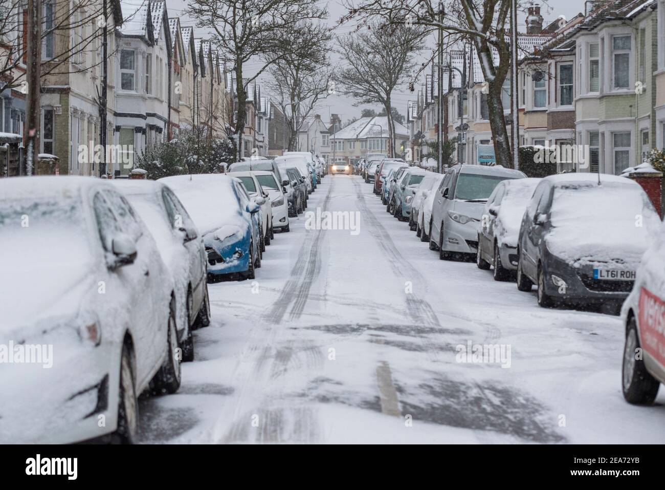 Westcliff on Sea, Essex, Großbritannien. Februar 2021, 8th. Der Schnee von Storm Darcy ist zugefroren und hat die Straßenverhältnisse tückisch gemacht. Eine Straße in Westciff on Sea ist eisig mit Autos mit Schnee bedeckt Stockfoto