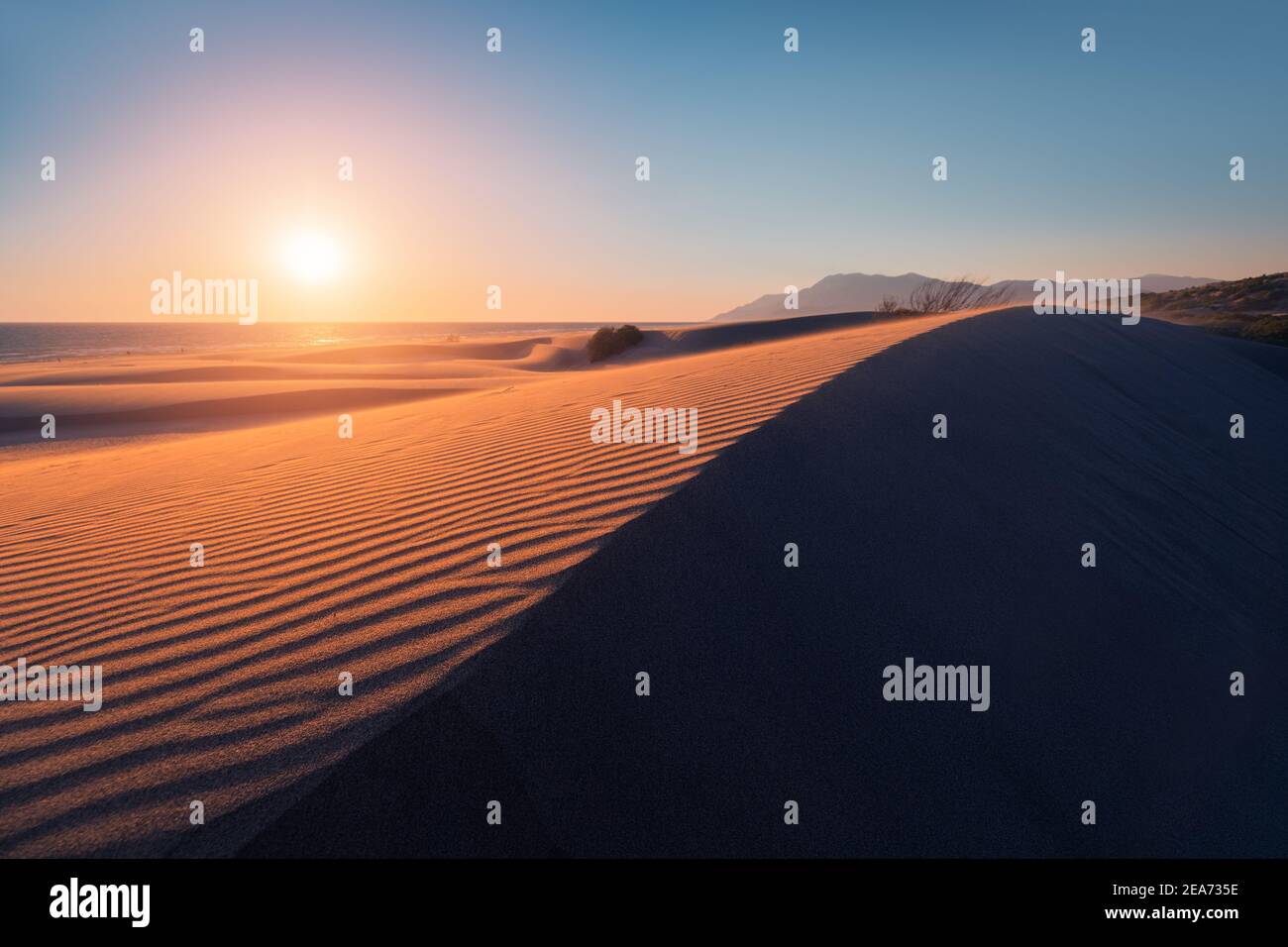 Stimmungsvolles und mystisches stimmungsvolles Licht des Sonnenuntergangs-Sonnenstrahls beleuchtet Der Hang einer Sanddüne irgendwo in der Tiefe Der Sahara Stockfoto
