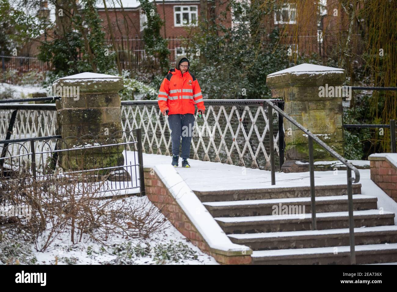 Royal Leamington Spa, Warwickshire, Großbritannien. 8th. Februar 2021: Ein Postbote geht zum Joggen im Schnee. Kredit: Ryan Underwood / Alamy Live Nachrichten Stockfoto