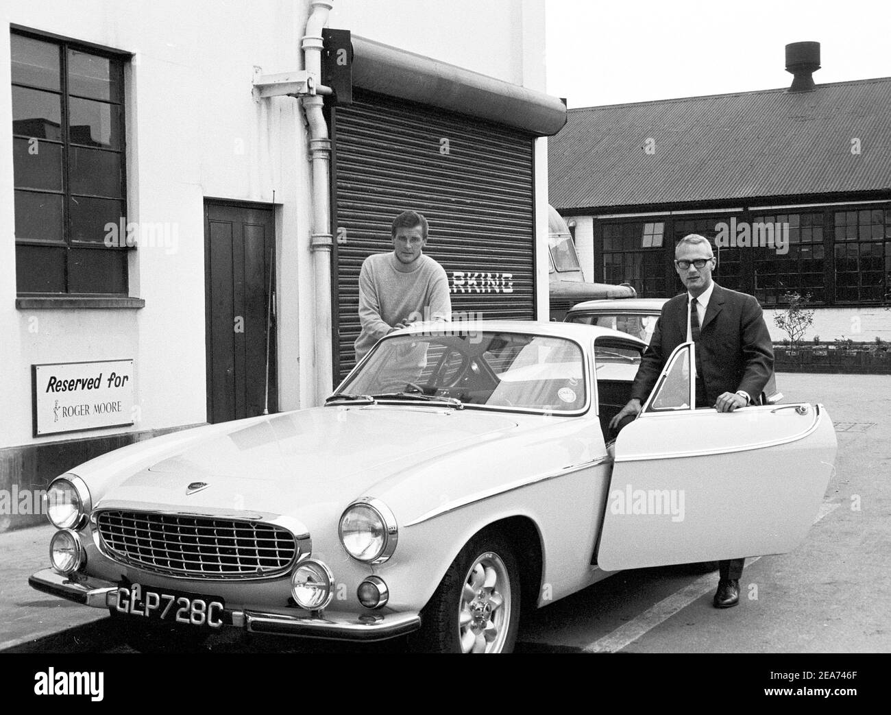 Volvo P1800. Ein Sportwagen von Volvo Cars mit Produktionsstart 1961 bis Ende 1973. Styling wurde von der schwedischen Designerin Pelle Pettersson. Der Wagen wurde 1961 auf dem Genfer Autosalon vorgestellt. Das Modell P1800 verkaufte 47492 Autos.der P1800 wurde weithin bekannt, als er von dem damaligen zukünftigen James Bond Schauspieler Roger Moore als Simon Templar in der Fernsehserie The Saint gefahren wurde. Im Bild Sir Roger Moore , 1927-2017 während der Dreharbeiten zur tv-Serie The Saint, posiert mit einem Volvo P1800 zusammen mit dem schwedischen Medienmann Dennis Sjöberg. Der Heilige lief von 1962 für sechs Staffeln und 118 Episoden. 1966 Stockfoto