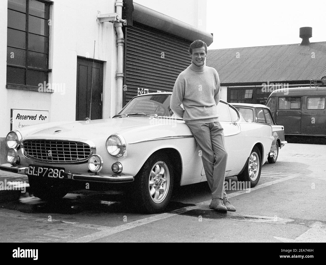 Volvo P1800. Ein Sportwagen von Volvo Cars mit Produktionsstart 1961 bis Ende 1973. Styling wurde von der schwedischen Designerin Pelle Pettersson. Der Wagen wurde 1961 auf dem Genfer Autosalon vorgestellt. Das Modell P1800 verkaufte 47492 Autos.der P1800 wurde weithin bekannt, als er von dem damaligen zukünftigen James Bond Schauspieler Roger Moore als Simon Templar in der Fernsehserie The Saint gefahren wurde. Im Bild Sir Roger Moore , 1927-2017 während der Dreharbeiten zur tv-Serie The Saint, posiert mit einem Volvo P1800. Der Heilige lief von 1962 für sechs Staffeln und 118 Episoden. 1966 Stockfoto