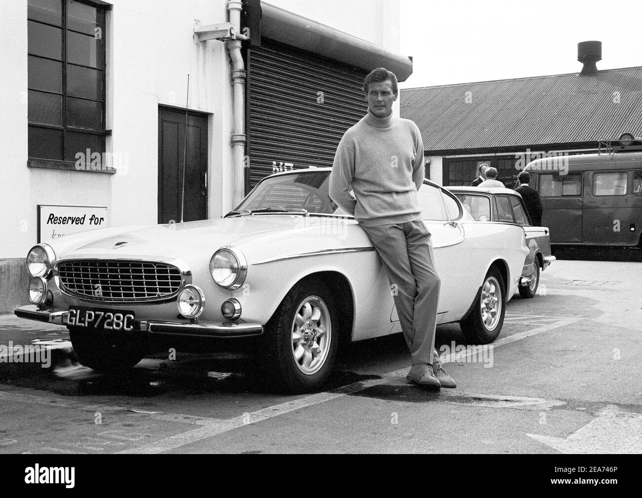 Volvo P1800. Ein Sportwagen von Volvo Cars mit Produktionsstart 1961 bis Ende 1973. Styling wurde von der schwedischen Designerin Pelle Pettersson. Der Wagen wurde 1961 auf dem Genfer Autosalon vorgestellt. Das Modell P1800 verkaufte 47492 Autos.der P1800 wurde weithin bekannt, als er von dem damaligen zukünftigen James Bond Schauspieler Roger Moore als Simon Templar in der Fernsehserie The Saint gefahren wurde. Im Bild Sir Roger Moore , 1927-2017 während der Dreharbeiten zur tv-Serie The Saint, posiert mit einem Volvo P1800. Der Heilige lief von 1962 für sechs Staffeln und 118 Episoden. 1966 Stockfoto