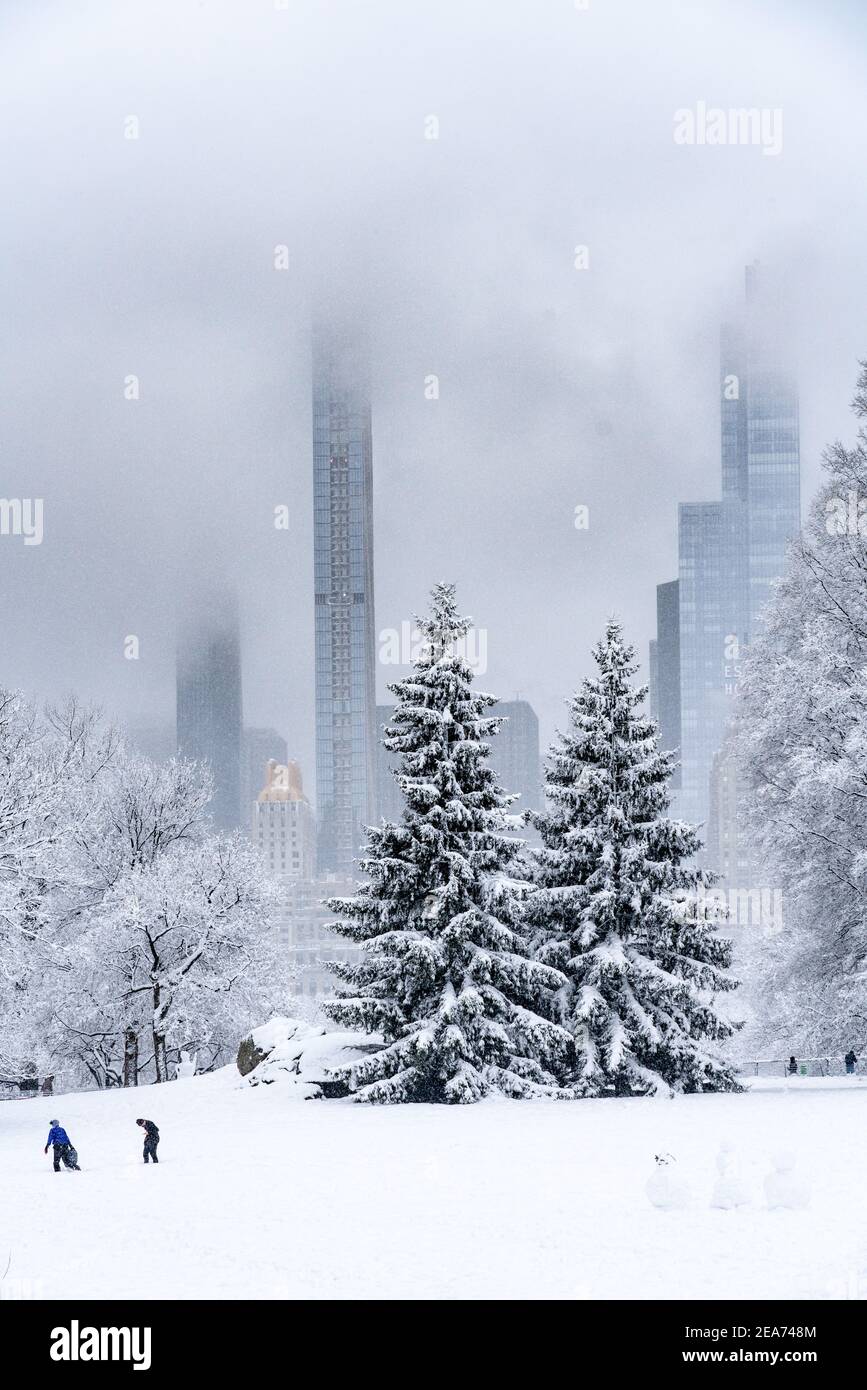 Menschen, die während eines Schneesturms im Central Park einen Schneemann bauen. Stockfoto
