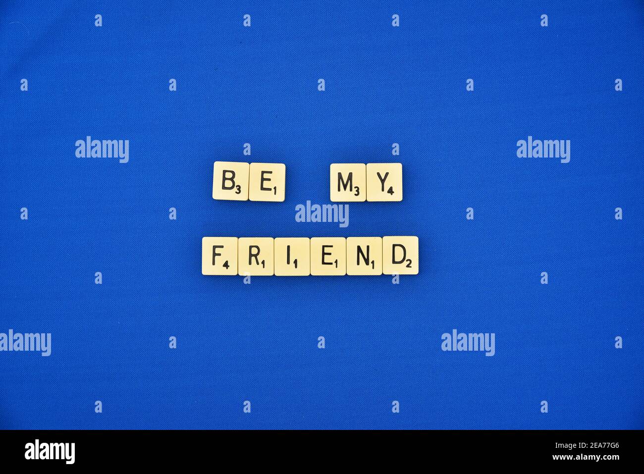 Scrabble Fliesen auf blauem Hintergrund Schreibweise Be My Friend Stockfoto