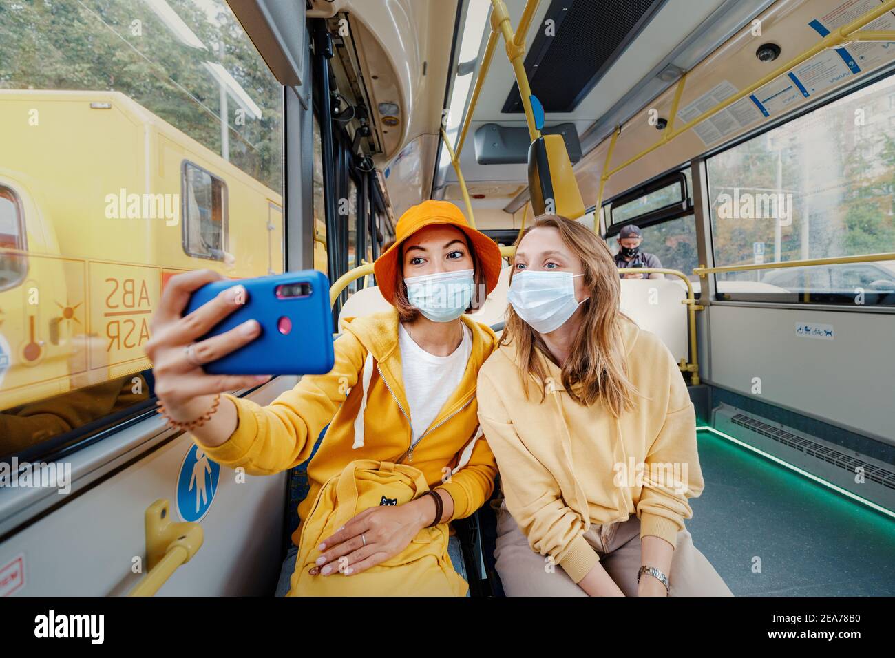 02. September 2020, Moskau, Russland: Zwei Freunde machen Selfie-Fotos in medizinischen Masken im Moskauer Bus. Einschränkungen durch Coronavirus und Quarantäne für Pub Stockfoto