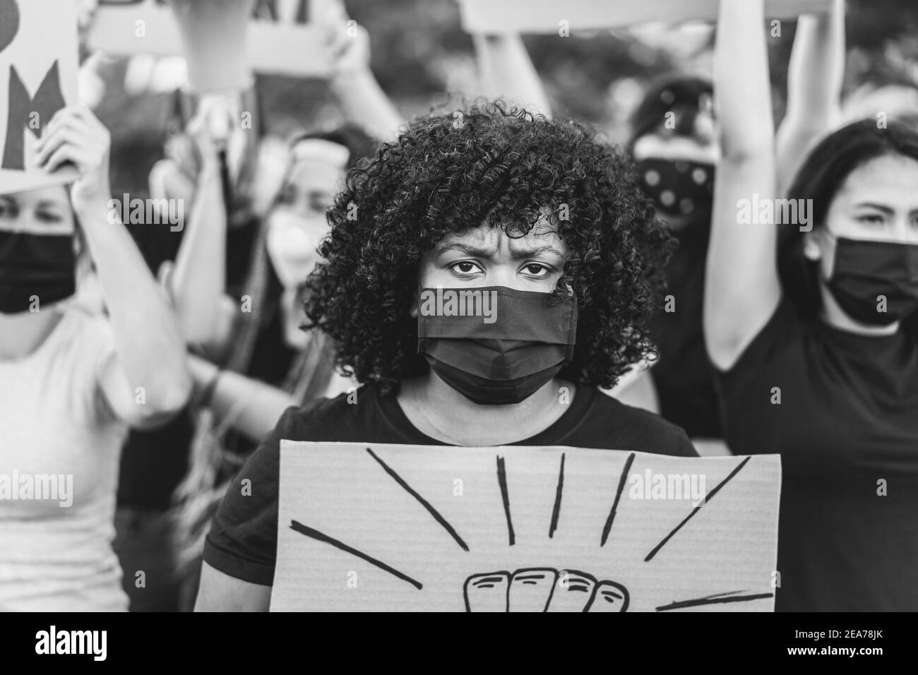 Menschen aus verschiedenen Kulturen und Rassen protestieren auf der Straße Für gleiche Rechte mit Sicherheitsmasken - Focus african Woman Stockfoto