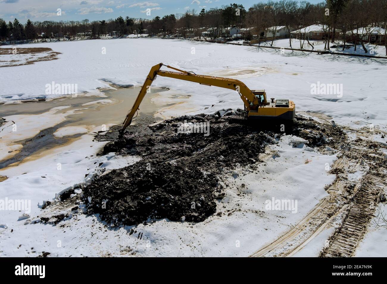 Reinigung der Boden des Sees ein Baggereimer ist Im Winter im Wasserbagger einweichen Stockfoto
