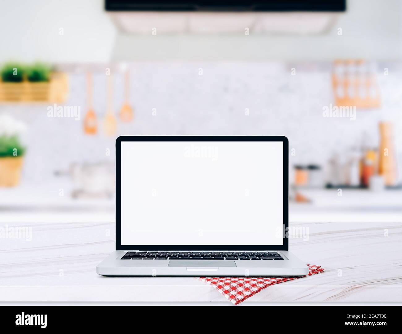 Moderner Computer, Laptop mit leerem Bildschirm auf Holztischplatte Unscharfer Küchenhintergrund Stockfoto