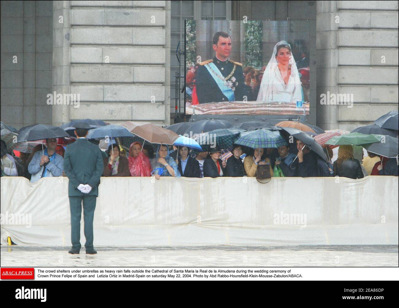 Die Menschenmenge versinkt unter Sonnenschirmen, wenn vor der Kathedrale Santa Maria la Real de la Almudena während der Hochzeitszeremonie von Kronprinz Felipe von Spanien und Letizia Ortiz in Madrid-Spanien am samstag, dem 22. Mai 2004, starker Regen fällt. Foto von Abd Rabbo-Hounsfield-Klein-Mousse-Zabulon/ABACA. Stockfoto