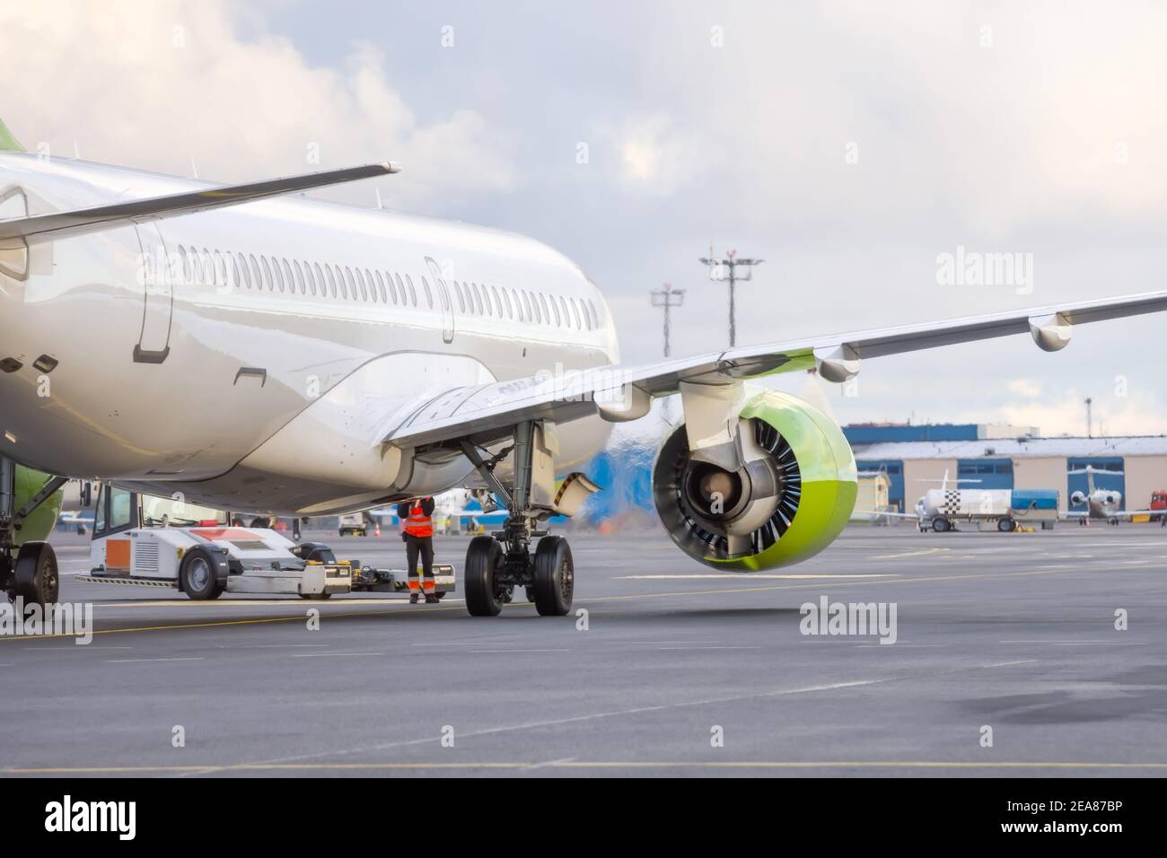 Das Flugzeug schiebt den Schlepper vor dem Starten der Motoren und Rollen, Rückansicht Stockfoto