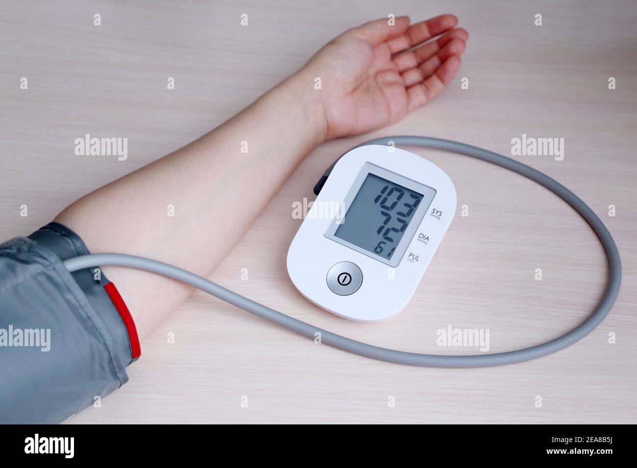 Frau, die den Blutdruck mit elektronischem Digitaltonometer misst, weibliche Hand aus nächster Nähe. Arterielle Hypotonie und kardiologisches Konzept Stockfoto