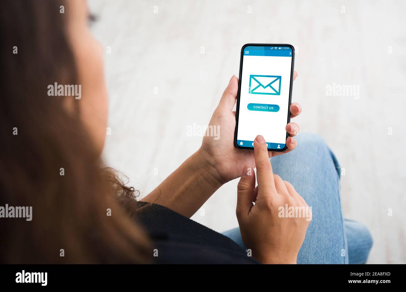 Frau mit Smartphone Senden einer neuen E-Mail-Nachricht Sitting Indoors, Cropped Stockfoto
