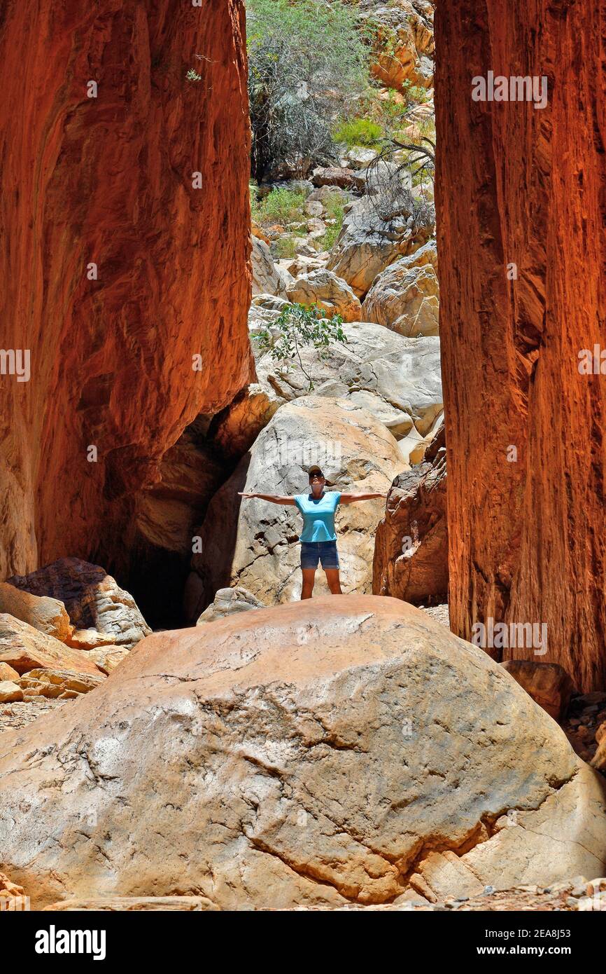 Australien, NT, Frau zwischen Felswand des atemberaubenden Stnadley Chasm im McDonnell Nationalpark in der Nähe von Alicve Springs MR verfügbar Stockfoto