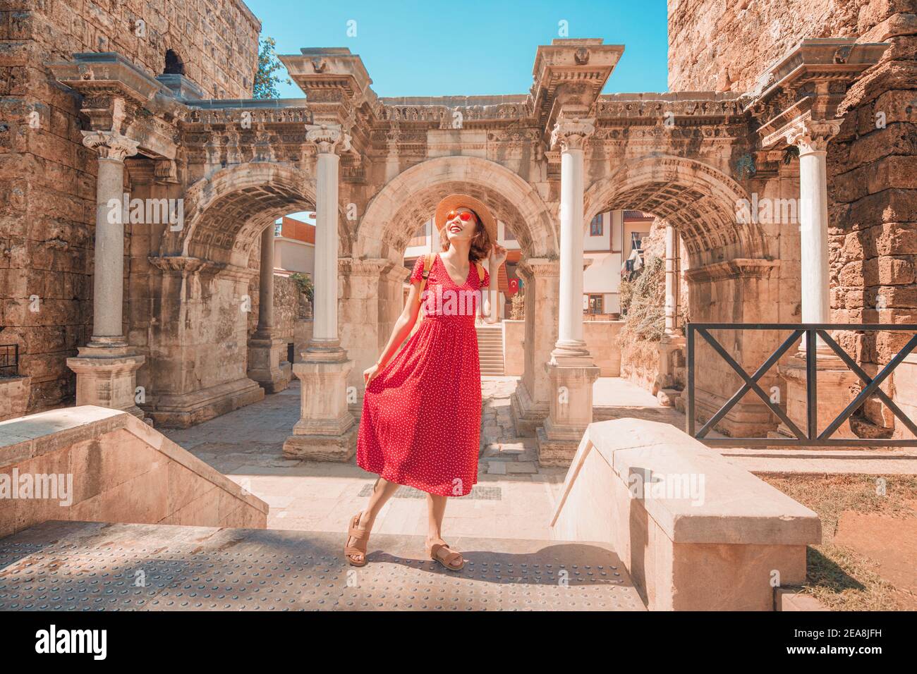 Glückliche weibliche Touristen entdecken interessante Orte und beliebte Sehenswürdigkeiten und Spaziergänge in der Altstadt von Antalya, Türkei. Das berühmte römische Tor Stockfoto